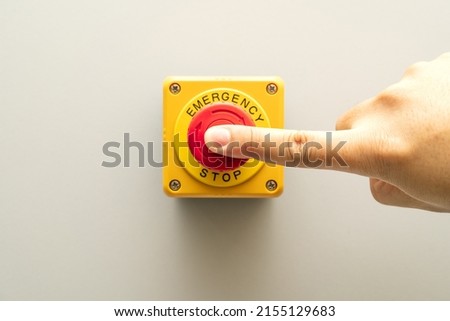 Stop Button and the Hand of Worker About to Press it. emergency stop button. Big Red emergency button or stop button for manual pressing. Royalty-Free Stock Photo #2155129683