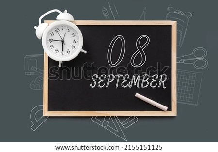 september 8. 8th day of month, calendar date. Blackboard with piece of chalk and white alarm clock on green background. Concept of day of year, time planner, autumn month.