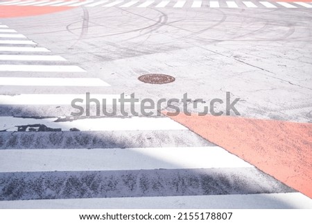 Abstract street pattern with markings of crosswalks and multiple tracks of rubber without a clear direction. Abstract wallpaper, background conveying a feeling of being at a crossroads.  