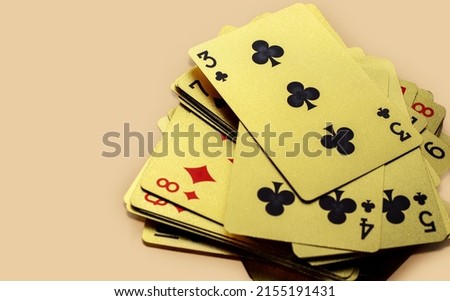 golden casino playing cards in a row or chaotic arrangement on orange background. four aces isolated, joker card on the top. Gold plated poker playing cards. luxury,waterproof