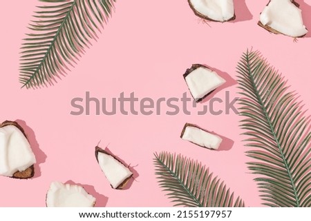 Summer creative layout with coconut pieces and palm leaves on pastel pink background. 80s or 90s retro aesthetic fashion background. Tropical fruit summer idea with copy space. Royalty-Free Stock Photo #2155197957