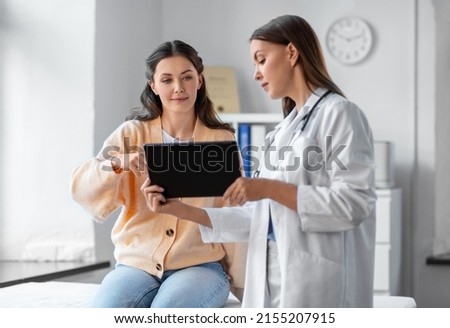 medicine, healthcare and people concept - female doctor with tablet pc computer talking to woman patient at hospital Royalty-Free Stock Photo #2155207915