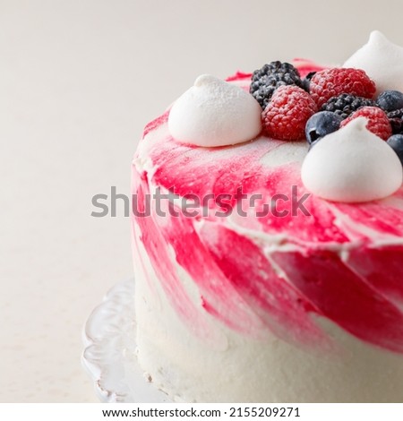 Homemade delicious mousse cake, glazed white chocolate, decorated with blueberries, raspberries, blackberries, meringue and powdered sugar. Berry cheesecake. Healthy dessert. Square picture, close-up