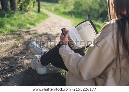 Girl with the Bible in nature. beautiful christian picture.