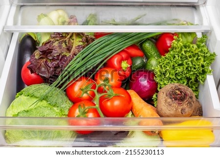 Vegetable compartment of the refrigerator full of fresh vegetables. Open fridge, drawer filled with fresh vegetables. Royalty-Free Stock Photo #2155230113