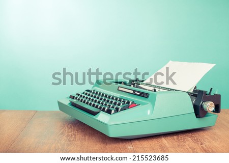 Retro old typewriter with paper on wooden table front mint green background Royalty-Free Stock Photo #215523685