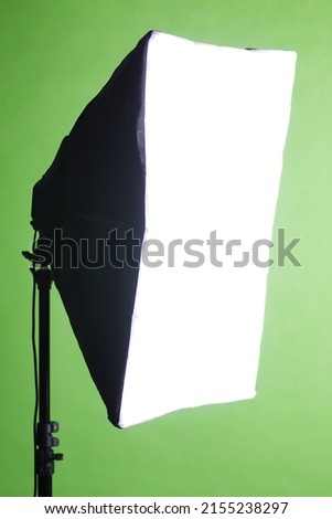 Studio lighting soft box on tripod and professional green screen background chroma key post production technique shooting or filming for movie or video commercial set up.