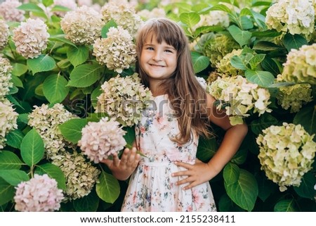 Happy pretty girl in 
green and pink hydrangea (authoring photo)