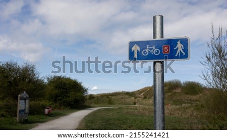 selective focus of cycle path footpath directional sign in blue at Talacre dunes north wales