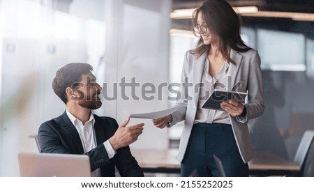 Smiling secretary brought the documents to the boss to sign after meeting