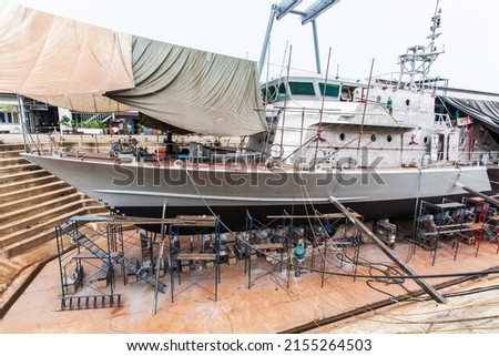 A patrol vessel or military vessel building in a dry dock at a naval shipyard. Royalty-Free Stock Photo #2155264503