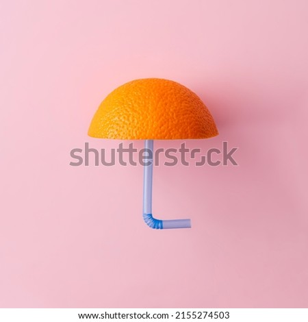 Summer or spring umbrella made with fresh orange and blue drinking straw. Creative weather or food concept on bright pink background. Minimal art idea.