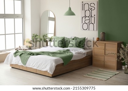 Interior of stylish room with big bed and mirror Royalty-Free Stock Photo #2155309775