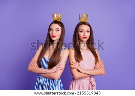 Photo of confident pretty two girlfriends wear dresses hair accessories arms folded isolated violet color background