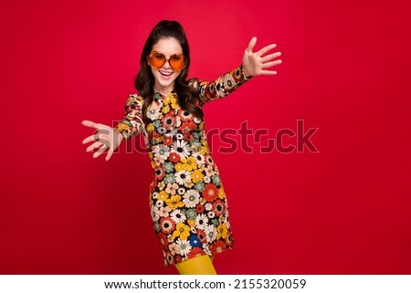 Photo of shiny excited woman wear flower print dress hear eyewear open arms empty space isolated red color background Royalty-Free Stock Photo #2155320059