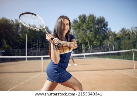 Caucasian female tennis player holding a racket and posing for a photo
