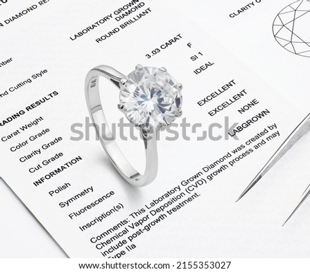 Lab-Created Diamond on Lab Diamond Report Background. Ethical Diamond Photograph. Royalty-Free Stock Photo #2155353027