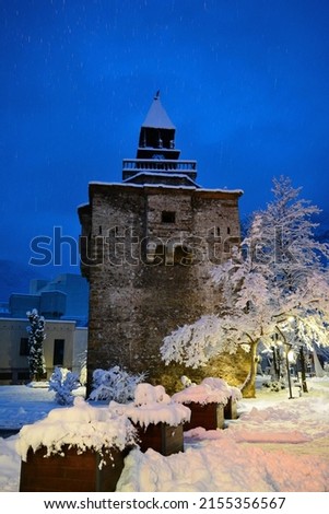 Clock towers of Europe. Magical winter landscape at the city of Vratsa, Bulgaria. Winter blue hour picture of covered with snow fortified stone clock tower. Vertical  image.