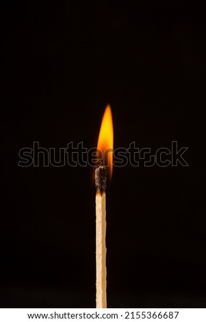 Burning matchstick on black background Royalty-Free Stock Photo #2155366687