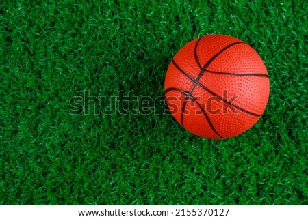 Close up of basketball ball on green grass background.