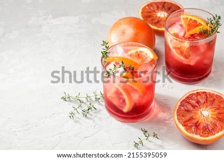 Red cocktail in base of Campari or bitter with  Sicilian red oranges (tarocco) on light gray concrete background, copy space. Aperitif with Americano cocktail. Natural  eco aesthetic, summer light Royalty-Free Stock Photo #2155395059