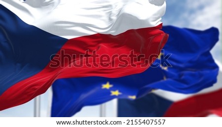 Detail of the national flag of Czech Republic waving in the wind with blurred european union flag in the background on a clear day. Democracy and politics. European country. Selective focus. Royalty-Free Stock Photo #2155407557