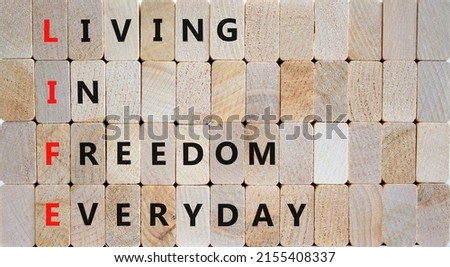 LIFE living in freedom everyday symbol. Concept words LIFE living in freedom everyday on wooden blocks on a beautiful wooden background. Business LIFE living in freedom everyday concept. Copy space.