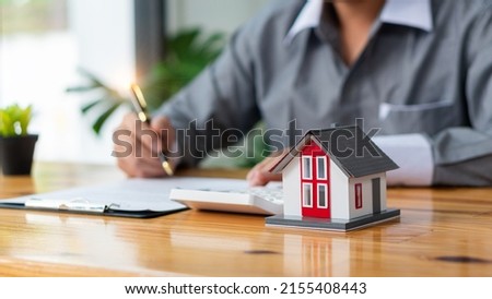 Businessmen holding pens, signing home titles with insurance, care about real estate services and the idea of real estate agents offering interest in installments to their customers. Royalty-Free Stock Photo #2155408443