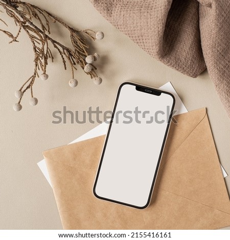 Flatlay of blank screen mobile phone, linen cloth on neutral beige background. Aesthetic home office desk workspace. Lady, girl boss business, work, blog template with mockup space. Flat lay, top view