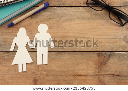 Top view image of man and woman figures over wooden table