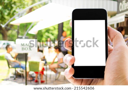 Close up of hand man using his cell phone with blank screen, blurred  outdoor people at coffee cafe