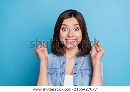 Photo of glad cheerful person raise fists delighted attainment toothy smile isolated on blue color background