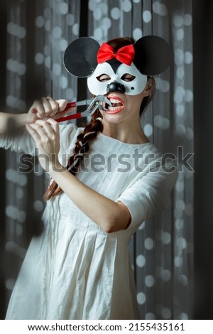 Woman in a mask of Minni Mouse showing child's fear of a dentist