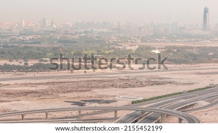 Top view city traffic on a crossroad in Business bay timelapse. Aerial top view of road junction and Deira district from above. Bridge over canal