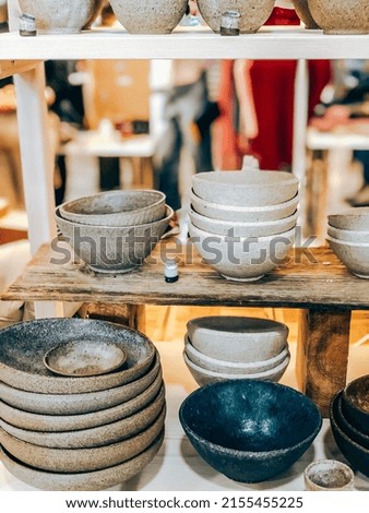 Handmade craft glazed modern ceramics shop. Eco friendly sustainable tableware wabi sabi style shopping on local market. Side view Royalty-Free Stock Photo #2155455225