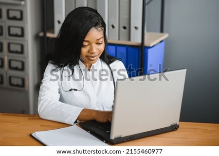 healthcare, medical and technology concept - african female doctor with laptop. Royalty-Free Stock Photo #2155460977