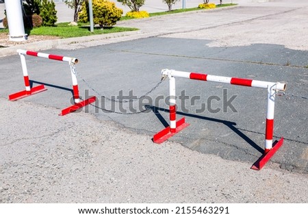 Metal road barrier with red and white striped caution pattern, road closed