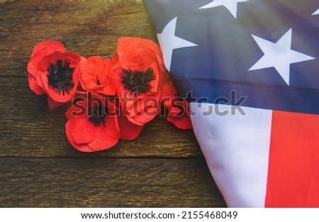 Text Memorial Day on American flag And a poppy flower background	
