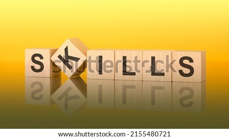 wooden blocks with the letters Skills on the bright surface of a yellow table. inscription on the cubes is reflected from the surface