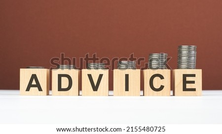 ADVICE text on wooden blocks with coins on brown background, business concept