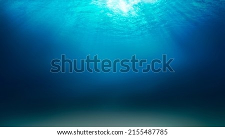 Sunlight shining through the surface of the blue ocean, sea, with dark waters and sandy seabed below. Royalty-Free Stock Photo #2155487785