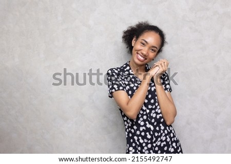 Beautiful Smiling Young african american Woman with Clean, Fresh, Glow, and perfect Skin Happy, healthy, cheerful, relaxing girl on grey background.
