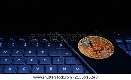 Bitcoin logo displayed on smartphone with keyboard background 