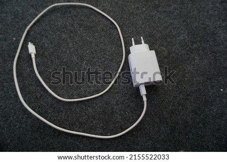 is a mobile phone charger that is white with a gray background