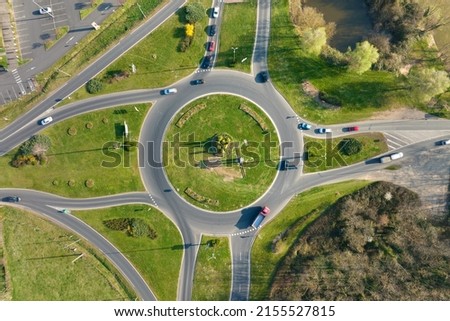 Aerial view of road roundabout intersection with moving heavy traffic. Urban circular transportation crossroads Royalty-Free Stock Photo #2155527815
