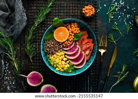Buddha bowl: quinoa, spinach, corn, tomatoes and watermelon radish, sea buckthorn. Healthy vegetarian eating, super food. Top view On a stone background.