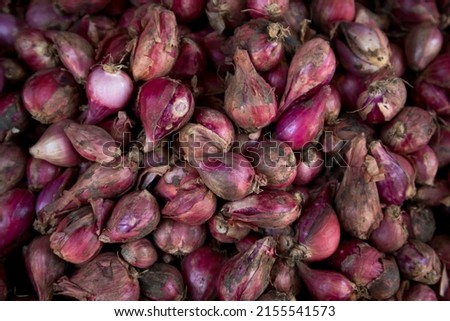 pile of unpeeled shallots at the traditional market