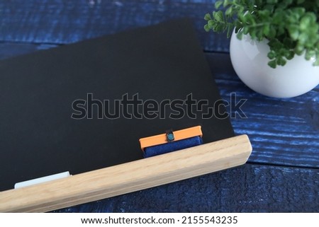 A small blackboard and chalk on the table and a blackboard eraser
