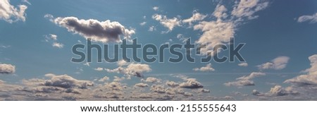 Background of light blue sky with white fluffy clouds at the bottom