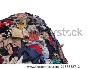 large pile stack of textile fabric clothes and shoes. concept of recycling, up cycling, awareness to global climate change, fashion industry pollution, sustainability, reuse of garment Royalty-Free Stock Photo #2155556713